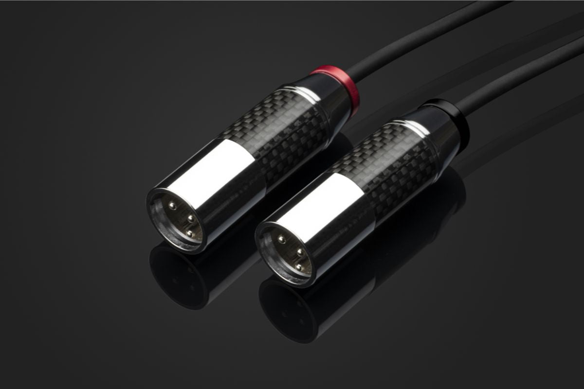 Nahaufnahme von zwei hochwertigen XLR-Audiokabeln mit Carbongehäuse auf schwarzem Hintergrund.