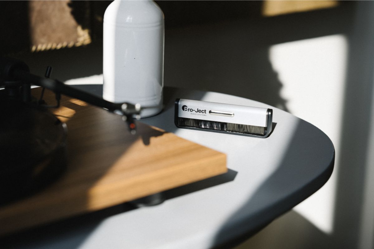 Schallplattenbürste von Pro-Ject liegt auf einem runden Tisch neben einem Plattenspieler