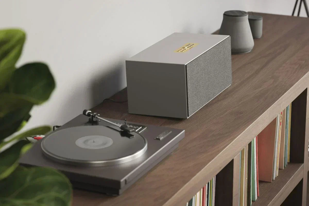 Audio Pro C20 Multiroom-Lautsprecher in Grau neben Plattenspieler auf Holzregal