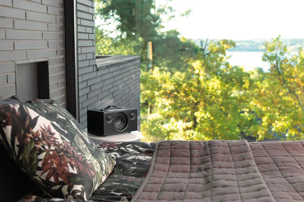 Audio Pro C5 MkII Multiroom-Lautsprecher in Schwarz auf Nachttisch im Schlafzimmer mit Panoramablick